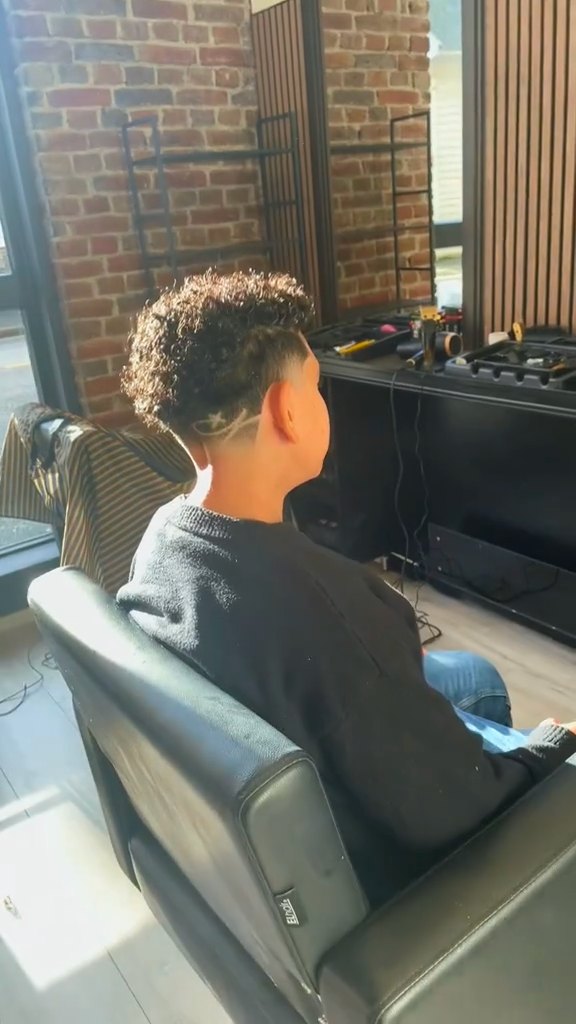 Krøller på toppen med fade og design på siden